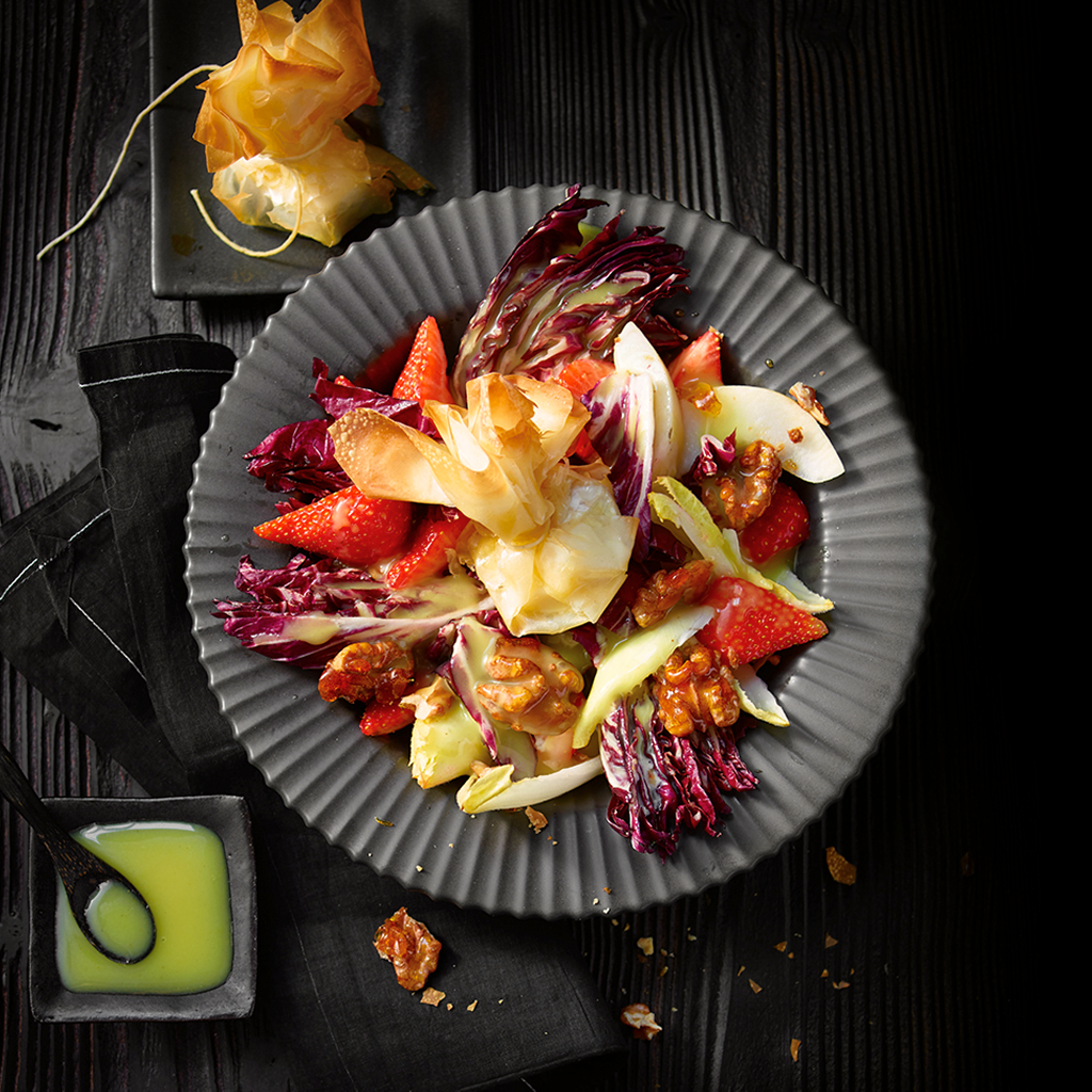 Frisch angerichteter Brie Meets Salad mit cremigem Brie, knackigem Gemüse, frischen Toppings und leichtem Dressing in einer Salatschüssel serviert.